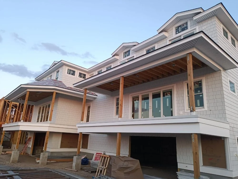 A new coastal house under construction showing deep roof overhangs carried on timber posts